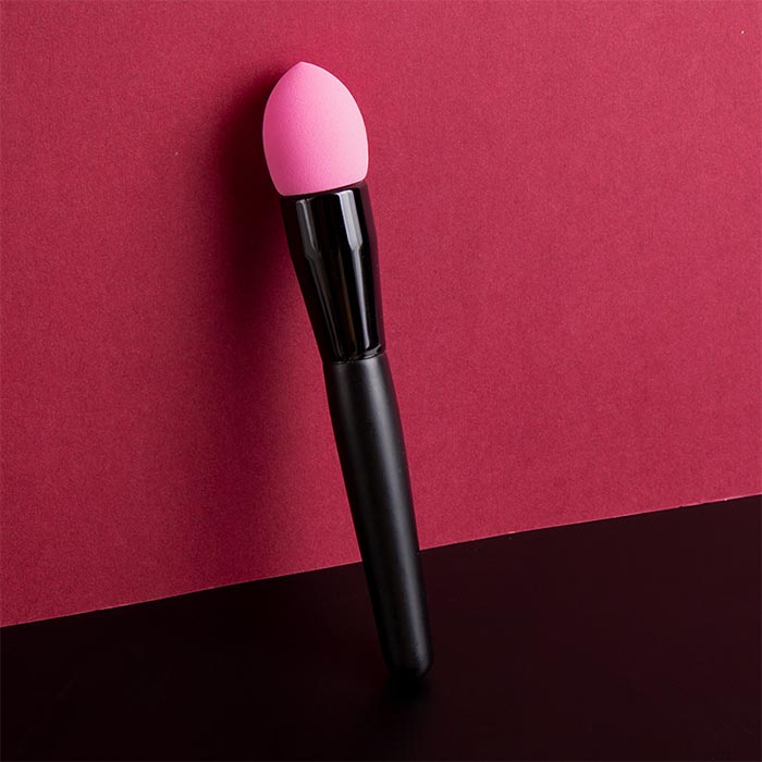 Black-handled pink makeup sponge