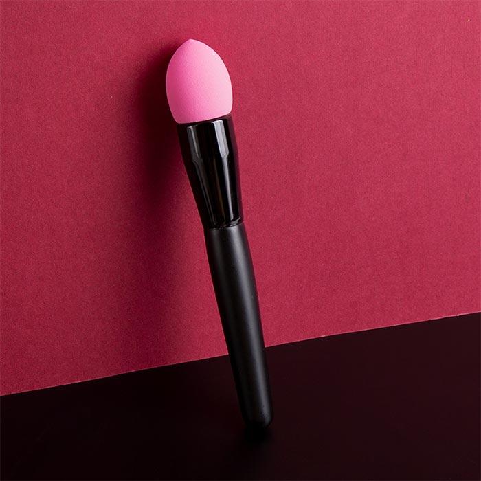 Black-handled pink makeup sponge