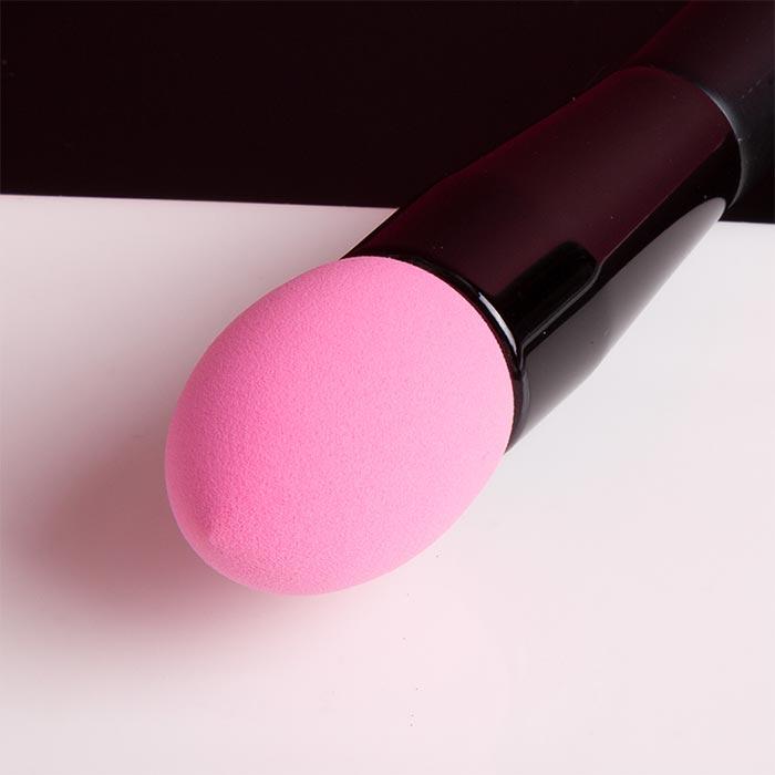 Black-handled pink makeup sponge